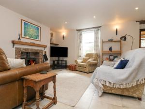 a living room with a couch and a fireplace at Woodbine Cottage in Falmouth