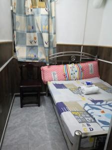een kleine kamer met een bed en kussens erop bij NEW WASHINGTON GUEST HOUSE B1,B2 B LOCK 13 FLOOR CHUNG KING MANSHION, 36-44 NATHAN ROAD KOWLOON HONG KONG in Hong Kong