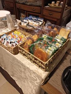 una mesa con dos cestas de alimentos y otros alimentos en PèPè Bed & Breakfast en Nápoles