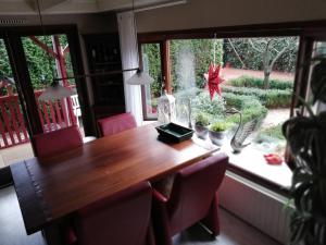 een eettafel met roze stoelen en een raam bij Oase rust en privacy op de Veluwe voor 4 personen in Putten