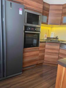 uma cozinha com um frigorífico de aço inoxidável e um micro-ondas em Priestranný 3 izb. apartmán v centre s parkovaním. em Banská Bystrica