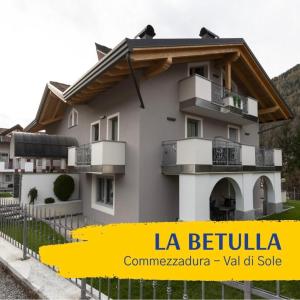 a building with balconies and a sign that says la bella at La Betulla Apartments in Commezzadura