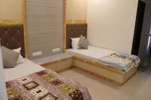 dwa łóżka w małym pokoju z dwoma w obiekcie Hotel Skylark w mieście Vapi