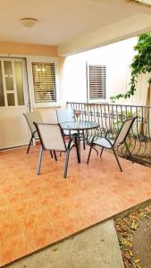 een patio met een tafel en stoelen op een balkon bij Apartment with a garden Petrovac in Petrovac na Moru