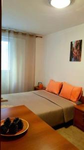 een slaapkamer met een bed en een bord op een tafel bij Apartment with a garden Petrovac in Petrovac na Moru