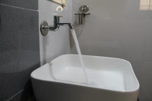 zlewozmywak ze strumieniem wody wylewającej się z kranu w obiekcie Hotel Skylark w mieście Vapi