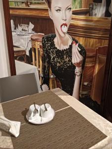 Eine Frau mit rotem Lippenstift im Gesicht, die an einem Tisch sitzt. in der Unterkunft PèPè Bed & Breakfast in Neapel