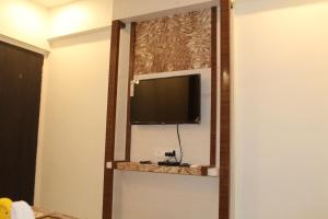 telewizor z płaskim ekranem na ścianie w pokoju hotelowym w obiekcie Hotel Skylark w mieście Vapi