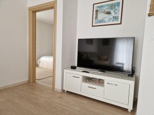 a living room with a flat screen tv on a white cabinet at Apartman Potok in Livno