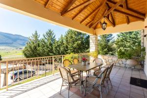 a patio with a table and chairs on a balcony at Pleiades All Season Gems - Korinthos Stone Retreats in Kalianoi