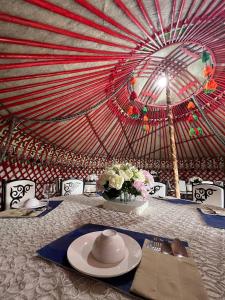 a table with a hat and flowers on top of a tent at As A Nomad Naryn Ethno Complex in Naryn
