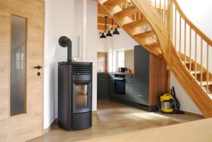 a kitchen with black appliances and a wooden staircase at Ferienhaus Schirgi in Sankt Kathrein am Offenegg