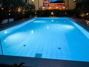 una piscina iluminada por la noche en Attico Riva Mare, en Muggia