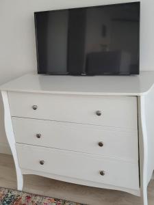 a white dresser with a tv on top of it at Апартаменты in Rīga