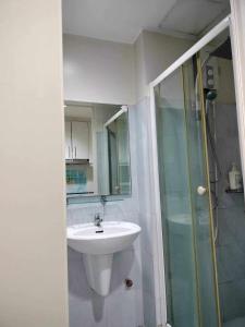 een badkamer met een wastafel en een douche bij Sea Fearer's condotel Pasay Moa in Manilla