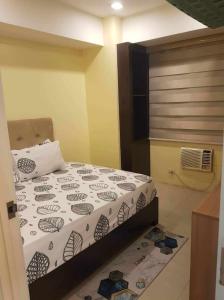 een slaapkamer met een bed met een dekbed erop bij Sea Fearer's condotel Pasay Moa in Manilla