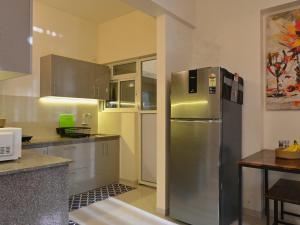 a kitchen with a stainless steel refrigerator and a table at No Fixed Address in Marmagao