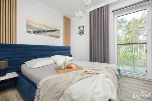 a bedroom with a blue bed with a tray of fruit on it at Apartament BLUE 17 z basenem in Pobierowo +35 photos