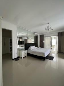 a large bedroom with a bed and a mirror at SunnyRent. Luxury TJ White Villa & Room in Ungasan