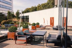 a group of chairs and tables in front of a building at Novotel Le Havre Centre Gare in Le Havre