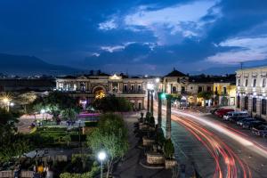 a city street at night with cars at Central Park Jr. Suites in Quetzaltenango