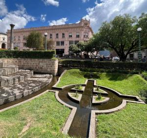 um parque com uma fonte em frente a um edifício em Central Park Jr. Suites em Quetzaltenango