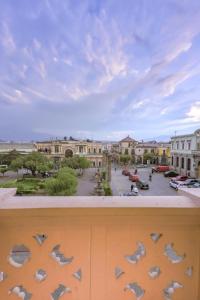 einen Balkon mit Blick auf die Stadt und Tauben in der Unterkunft Central Park Jr. Suites in Quetzaltenango