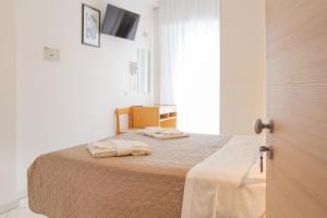 1 dormitorio con 1 cama con 2 toallas en Hotel Giulio Cesare, en Cattolica