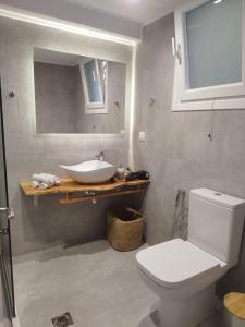 Łazienka z białą toaletą i umywalką w obiekcie Baracunda Apartments w mieście Barbati