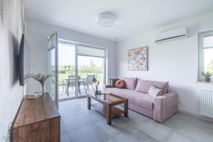 a living room with a couch and a table at Flatbook Apartamenty - Sztutowo Baltic Twins II in Sztutowo