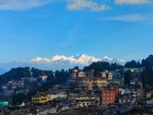 Blick auf eine Stadt mit Bergen im Hintergrund in der Unterkunft HOTEL PURNI DARJEELING in Darjeeling