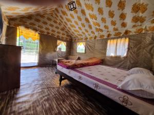 een slaapkamer met een bed in een tent bij Tree Bones Camp in Bir