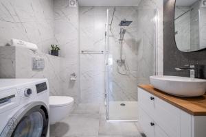 a bathroom with a shower and a washing machine at Flatbook Apartamenty - Sztutowo Baltic Twins II in Sztutowo