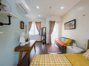 a living room with a bed and a couch at NẮNG House in Da Nang