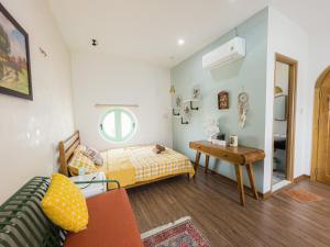 NẮNG House في دا نانغ: غرفة صغيرة بها سرير وطاولة
