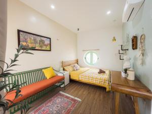 a bedroom with a bed and a couch in it at NẮNG House in Da Nang