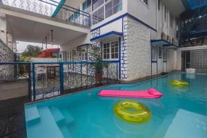 a swimming pool with two oogie boards in the water at Stayscape Casa Santorini 4BHK Lonavala in Oxel +12 photos