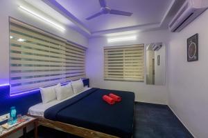 a bedroom with a bed with a red pillow on it at Stayscape Casa Santorini 4BHK Lonavala in Oxel