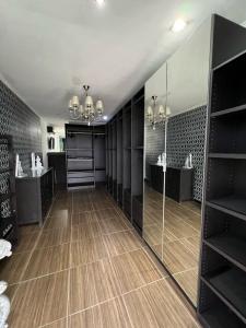 a walk in closet with a large mirror and shelves at SunnyRent. Luxury TJ White Villa & Room in Ungasan