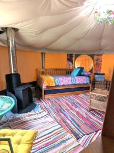 a bedroom with a bed and a rug in a tent at Luxury Private Glamping in the Stargazer Geo Dome, Yurt or Converted Caravan Beautiful Pembrokeshire Setting close to Narberth in Narberth
