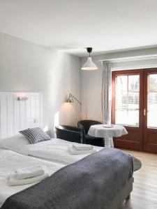 a bedroom with two beds and a chair and a table at Landhaus Nordstern Hotel garni in Utersum