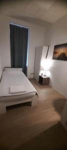 Dormitorio blanco con cama y lámpara en W&V Hostel, en Viena