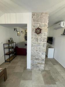 a living room with a stone wall with a clock at TRE SORELLE in Piran