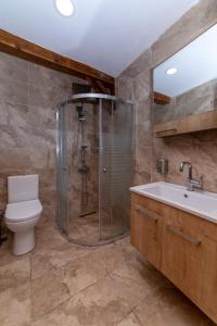 a bathroom with a shower and a toilet and a sink at Kite Beach Otel in Mugla