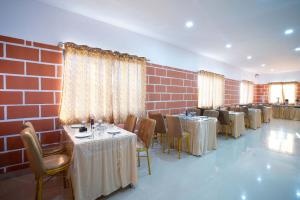 a restaurant with tables and chairs and a brick wall at Treebo Trend Galaxy Kings Suites in Bangalore