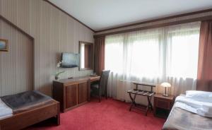 a hotel room with a bed and a desk and a television at Centrum Rekreacji HARENDA in Ludwikowice Kłodzkie