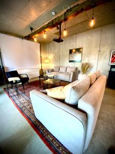 a living room with white couches and a rug at WATERFRONT - Urbane Eleganz am Bachufer in Villach