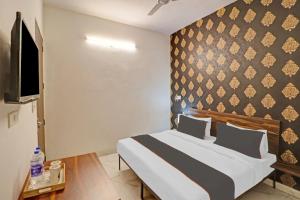 ein Schlafzimmer mit einem Bett und einer Wand in der Unterkunft OYO Town Plaza in Neu-Delhi