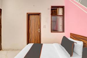 Schlafzimmer mit einem Bett und einer Holztür in der Unterkunft OYO Town Plaza in Neu-Delhi