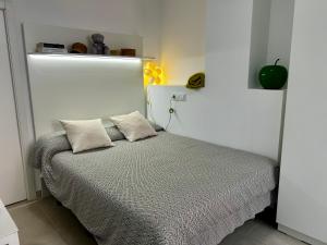 a bedroom with a bed with two pillows on it at STUDIO Palomar - PalomarGroup in Alfara del Patriarca